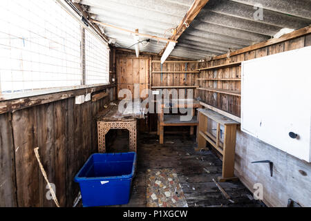 L'intérieur d'un vieux hangar abandonné avec des workbench, placards, étagères, toit de l'amiante et le dangereux. Banque D'Images