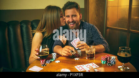 Les amis assis à table en bois. Les amis de s'amuser tout en jouant à jeu de plateau. Banque D'Images