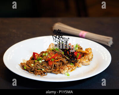 Nouilles de sarrasin Soba, oignon, carotte, poivron, bulgare, cuisses de poulet, hot chili peppers sauce Chili, l'oignon vert. Banque D'Images