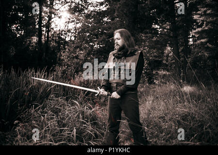 Le barbu Knight. Un gars dans un costume médiéval avec une épée. Toning Banque D'Images