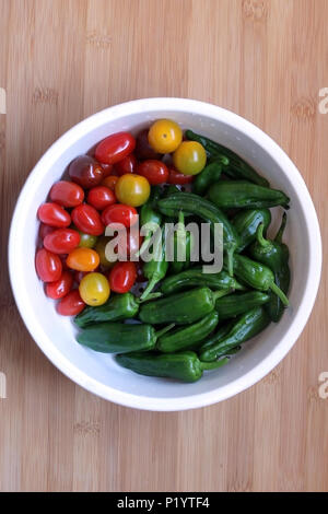 Coup de frais généraux de fraîchement lavé les tomates cerises et poivrons Padron préparé pour les grillades d'été Fête Banque D'Images