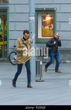 Graz, Autriche - 23 octobre 2017 : deux hommes avec des téléphones portables dans les mains sur Hauptplatz Banque D'Images