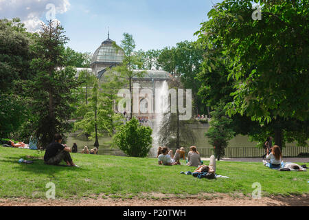 Parc de Madrid en été, vue des jeunes se détendant un après-midi d'été près du Palacio Cristal dans le Parque del Retiro, Madrid, Espagne. Banque D'Images