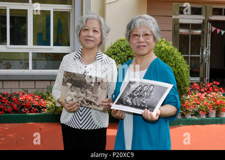 Shanghai, Chine. 12 Juin, 2018. Xian Muzhen (L) et Xian Muhe posent avec des photos de leur enfant, pendant une exposition de photos qui s'est tenue à l'Institut du bien-être de la Chine (CWI) Pépinière de Shanghai, la Chine orientale, le 12 juin 2018. Cette année marque le 80e anniversaire du CWI, fondée par Soong Ching Ling en 1938. L'Organisation de Shanghai se concentre sur la santé maternelle et infantile, l'éducation et de la protection sociale. Soong Ching Ling, né à Shanghai en 1893, était l'épouse de révolutionnaires chinois du Dr. Sun Yat-sen, qui a dirigé la révolution de 1911. Credit : Gao Feng/Xinhua/Alamy Live News Banque D'Images