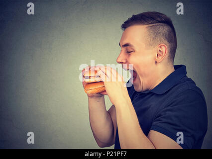 Man eating junk food double cheeseburger Banque D'Images