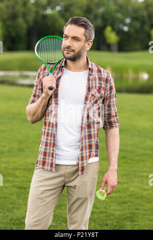 Beau barbu holding badminton racquet sur l'épaule et à l'écart Banque D'Images