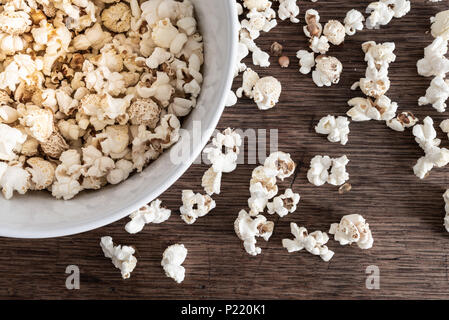 Directement au-dessus de close-up de bol rempli avec du popcorn sur table en bois rustique Banque D'Images