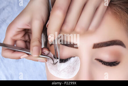 Procédure d'extension de cils close up. Belle Femme avec de longs cils en institut de beauté. Banque D'Images