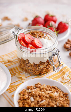 Granola fait maison dans un bocal en verre en couches avec le yogourt et fraises fraîches Banque D'Images