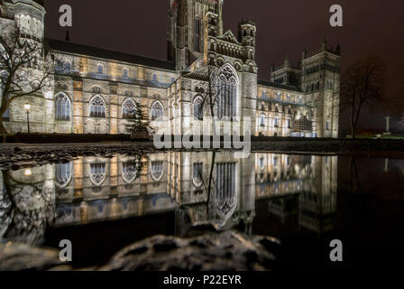 Cathédrale de Durham extérieur est éclairé la nuit, et se reflète dans une flaque sur le sol à l'extérieur Banque D'Images