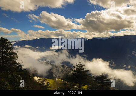 L'image est prise sur une colline, dans l'himalaya debout autour des nuages et soleil en essayant de sortir à travers les nuages. Banque D'Images