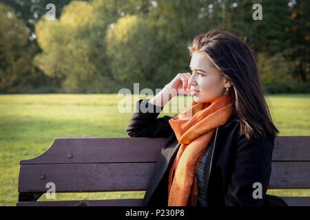 Jeune femme séduisante coin sur un banc dans le parc Banque D'Images