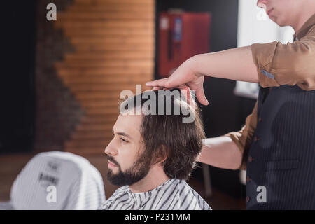 Cropped shot of coiffure peigner les cheveux du client à un barbier Banque D'Images