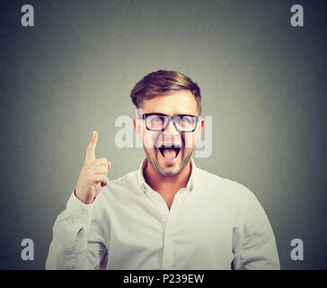 Jeune homme à lunettes à la caméra à tout excité et pointant vers le haut, la création d'idée. Banque D'Images