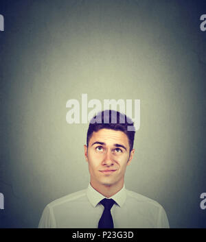 Douteux handsome businessman thinking looking up Banque D'Images