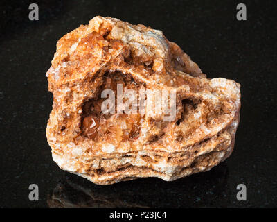 La prise de vue macro des eaux minérales naturelles - Wulfenite cristaux sur rough rock le granit noir de l'Oural Banque D'Images