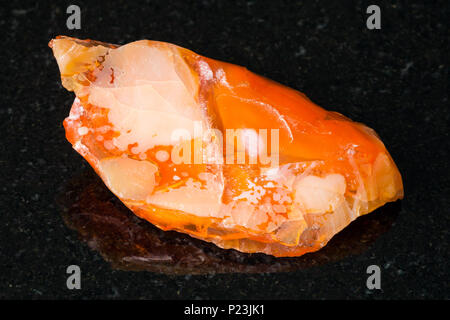 La prise de vue macro de matières premières minérales naturelles - opales et opale de feu sur pierre de granit noir de l'Oural Banque D'Images