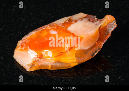 La prise de vue macro de matières premières minérales naturelles - opale noble et opale de feu sur pierre de granit noir de l'Oural Banque D'Images