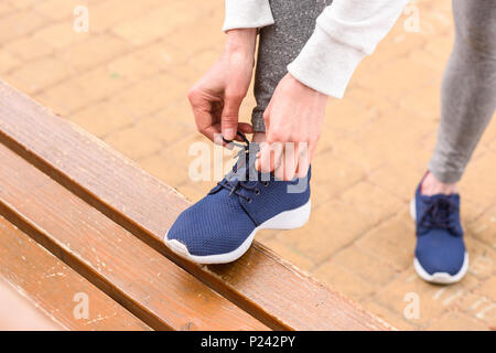 Portrait de liage de la sportive sur lacets sneakers bleu Banque D'Images