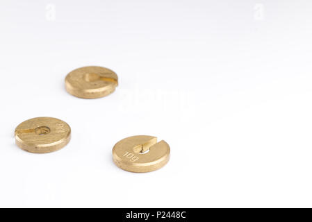 Couleur de l'or en laiton 10 grammes poids masses crénelé isolé sur un fond blanc. Concept scientifique Science Banque D'Images