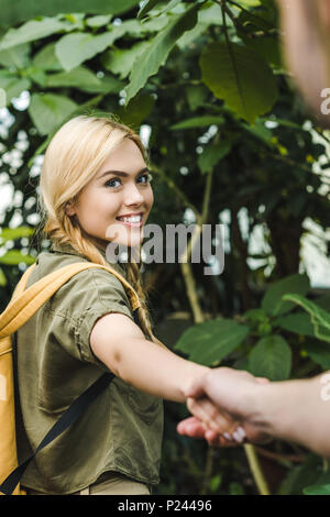 Jeune couple dans safari suits holding hands par in jungle Banque D'Images