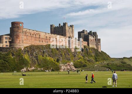 Les familles jouant sur le champ ci-dessous château de Bamburgh, Northumberland, Angleterre Banque D'Images