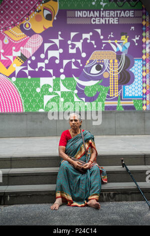 Singapour, République de Singapour, une femme assise sur les marches en face de l'Indian Heritage Centre Banque D'Images