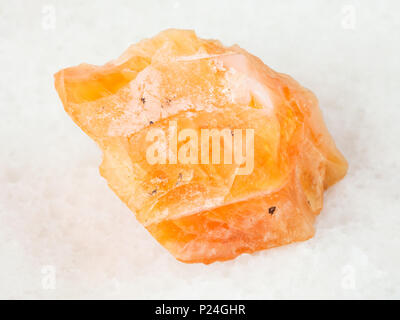 La prise de vue macro de matières premières minérales naturelles - opale de feu gemstone sur marbre blanc de l'Oural Banque D'Images