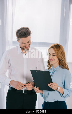 Portrait of smiling business colleagues with notepad in office Banque D'Images