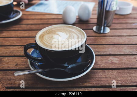 Close up image d'une tasse de café chaud dans une tasse noire Banque D'Images