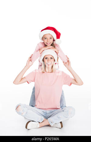 Happy mother and daughter wearing santa hats sur noël, isolated on white Banque D'Images