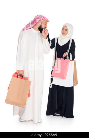 Heureux couple musulman with shopping bags isolated on white Banque D'Images