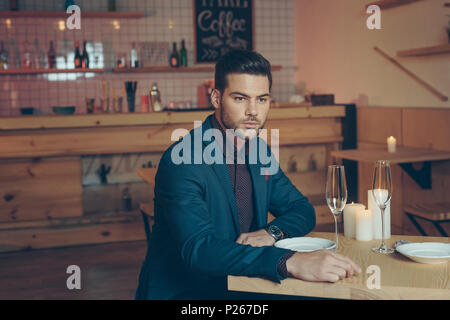 Portrait d'élégant pensive man sitting at table in restaurant Banque D'Images