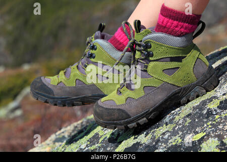 Chaussures de randonnée avec des roches de fond de montagne Banque D'Images