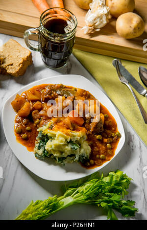 Ragoût de boeuf irlandais authentique avec de la bière du pain et de la purée de pommes de colcannon Banque D'Images