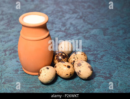 Lait et oeufs de caille sur un fond bleu foncé Banque D'Images