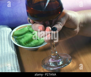 Vin rouge et une main de femme Banque D'Images