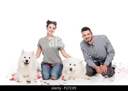 Couple avec des chiens et des confettis en forme de coeur sur blanc, concept de Jour de Valentines Banque D'Images