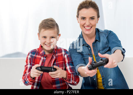 Mère et fils excité à jouer à des jeux vidéo avec les manettes de jeu ensemble Banque D'Images