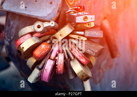 Close-up of red, white et autres serrures sous forme de cœur sur le vieux pont de la ville, la tradition des amoureux le jour du mariage Banque D'Images