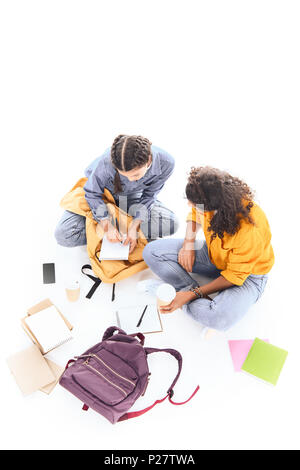Vue supérieure de l'élèves à faire leurs devoirs ensemble multiethnique isolated on white Banque D'Images