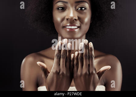 Belle african american woman montrant ses ongles isolated on black Banque D'Images