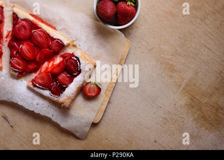 Tarte aux fraises avec du sucre en poudre sur une planche à découper Banque D'Images