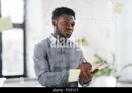Bureau d'affaires avec presse-papiers au mur de verre Banque D'Images