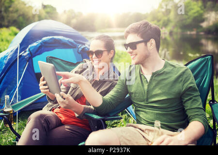 Couple heureux avec tablet pc at tente de camping Banque D'Images