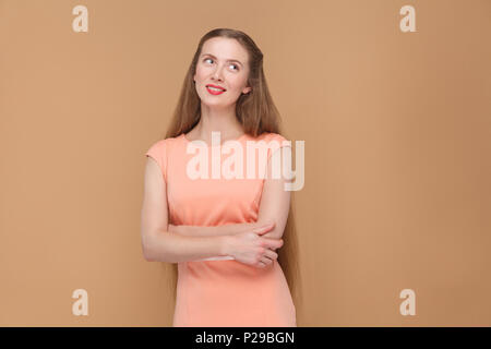 Méditer, rêver belle femme à la recherche de l'établissement. portrait d'une jolie, belle femme aux longs cheveux et maquillage en robe rose. Piscine studio s Banque D'Images