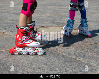 Patins à roulettes sur pieds, deux petites filles dans la formation de roller Banque D'Images