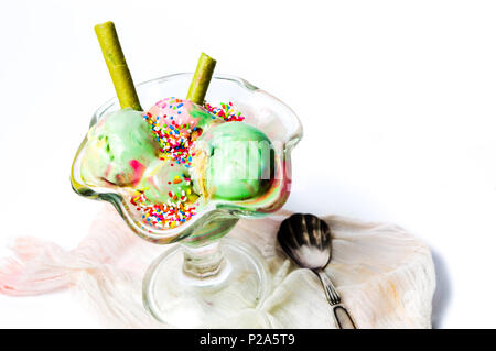 Le thé vert et de fruits mélangés dans une tasse de crème glacée Banque D'Images