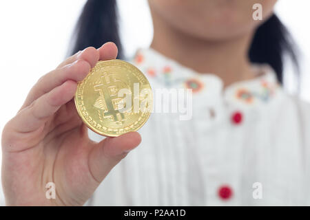 Children's hand holding golden fond blanc isolé en Bitcoin Banque D'Images