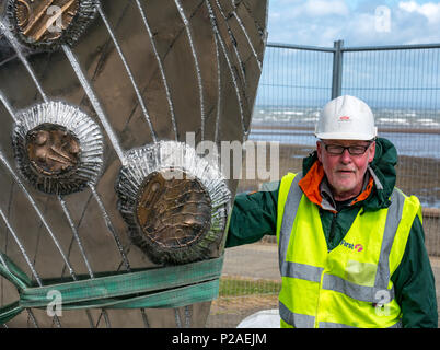 Musselburgh, East Lothian, Ecosse, Royaume-Uni, le 14 juin 2018. L'installation de sculpture par Michael Johnson, qui ses boulons en acier inoxydable de 2 tonnes sculpture 'Mémoire et réflexion" en place dans Murdoch vert. La coquille des moules en bronze poli à la main sculpture a cartouches représentant l'histoire de la ville et mesure 14 m de haut par 6 pieds de large. Conçu et construit par la Bretagne, sculpteur, il est commandé par l'East Lothian Council dans le cadre de sa politique des arts de pour cent et financé par Tesco. Le sculpteur a lutté avec Hector tempête Vent comme il a été placé. L'installation du sculpteur sculpture Banque D'Images